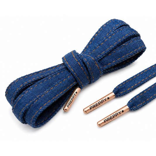 Blue denim flat laces with gold contrast stitching and rose gold metal tips branded with 'PREPPY*', arranged on a white background.