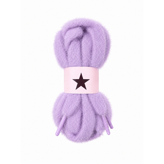 Fluffy, fuzzy lavender purple shoelaces wrapped in a light pink paper band featuring a black star, set against a plain white background.